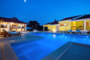 a swimming pool at night with blue lights at Villa Delmati in Tugare
