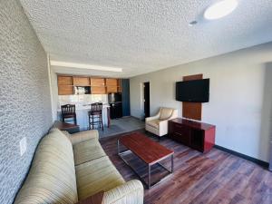 a living room with a couch and a table and a kitchen at North Villa extended stay in Houston