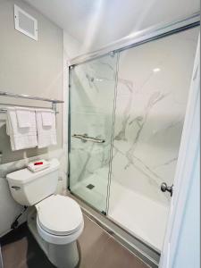 a bathroom with a toilet and a glass shower at North Villa extended stay in Houston