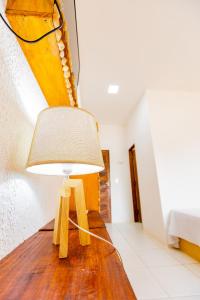 a lamp on a wooden table in a room at OYO Hotel Das Pedras in Parnaíba