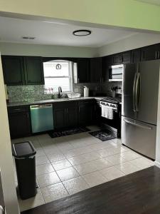 a kitchen with stainless steel appliances and a tile floor at Spacious Master Bedroom in Newark