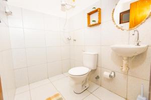 a bathroom with a toilet and a sink at OYO Hotel Das Pedras in Parnaíba