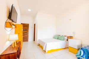 a bedroom with a bed and a tv on a wall at OYO Hotel Das Pedras in Parnaíba