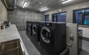 a laundry room with four washing machines in it at Iceland SJF Apartments - 301 in Reykjavík