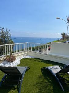 a balcony with chairs and a view of the ocean at Cap d.Azur in Roquebrune-Cap-Martin