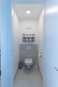a white bathroom with a toilet and a sink at Modern apartment with big balcony near city center in Vienna