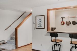 eine Küche mit Theke und Hockern in einem Haus in der Unterkunft 55SW - Fireplace - D W - WithD - Sleeps 4 condo in Glacier