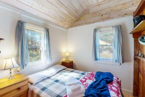 1 dormitorio con 1 cama y 2 ventanas en North Truro Bayside Gem, en Truro