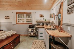 una cocina con fregadero y una cama en una habitación en 72MF - Rustic - Pets Ok - Sleeps 2 cabin, en Maple Falls