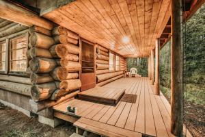 a log cabin with a wooden deck at 76GS - Genuine Log Cabin - WiFi - Pets Ok - Sleeps 4 home in Glacier