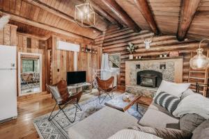 een woonkamer met een bank en een open haard bij 76GS - Genuine Log Cabin - WiFi - Pets Ok - Sleeps 4 home in Glacier