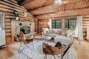 een woonkamer met een bank en een open haard bij 76GS - Genuine Log Cabin - WiFi - Pets Ok - Sleeps 4 home in Glacier