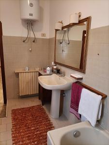 een badkamer met een wastafel, een spiegel en een bad bij Nurachi vacanza in Nurachi