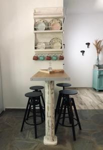 a table with two stools in a room at Vlami's House Andros in Apróvaton +25 photos