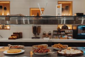 a counter with several plates of food on it at Gran Hotel Don Manuel in Cáceres