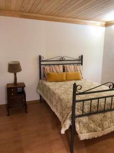 a bedroom with a bed and a lamp on a night stand at Quinta do Casal da Bica in Casal da Bica