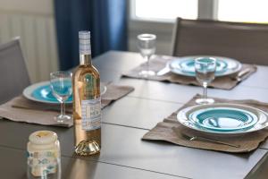 una botella de vino sentada en una mesa con copas en Magnificent Villa recent quiet St Denis D'Oléron, en Saint-Denis-dʼOléron