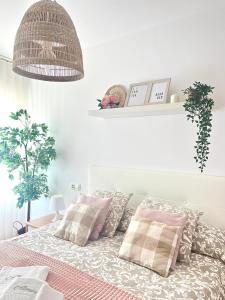 1 dormitorio con 1 cama con almohadas rosas y grises en Almar II - Padrón, en Padrón