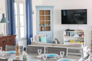 a living room with a couch and a tv at Magnificent Villa recent quiet St Denis D'Oléron in Saint-Denis-dʼOléron