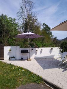 un patio con mesa y sombrilla en El Rinconin de Degu, en San Juan de Parres