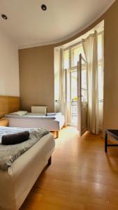 a bedroom with two beds and a large window at Central Station Hostel in Warsaw