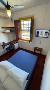 um quarto com uma cama com uma janela e uma cama sidx sidx em Pousada Aquarium Centro Histórico em Paraty