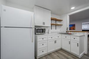  La cuisine est équipée de placards blancs et d'un réfrigérateur. dans l'établissement Cozy home away from home, à Los Angeles