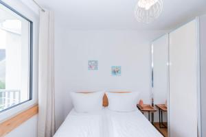 1 dormitorio con paredes blancas y 1 cama con almohadas en Modern apartment with private balcony near city center, en Viena