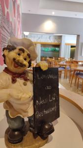 a statue of a chef holding a sign in a restaurant at New Life Piracicaba by Atlantica in Piracicaba