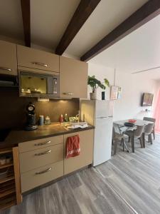 eine Küche mit einem weißen Kühlschrank und einem Tisch in der Unterkunft Appartement Argelès-sur-Mer avec piscine à 500m de la mer in Argelès-sur-Mer