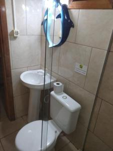 a bathroom with a toilet and a sink at Hotel Praia Do Rosa in Praia do Rosa