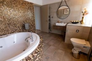 ein Badezimmer mit einer Badewanne, einem WC und einem Waschbecken in der Unterkunft Villa George in Skiathos in Skiathos-Stadt