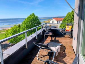 a balcony with chairs and a table and the ocean at Sunset Dream Apartment with a panoramic seaview in Haapsalu