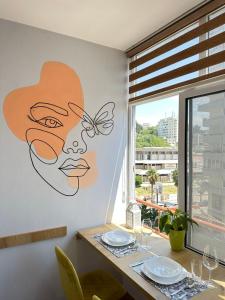 einen Esstisch mit einem großen Gesichtsbild in der Unterkunft Family Apartment Durres in Durrës