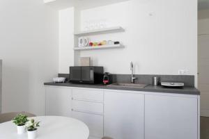 帕多瓦Residenza SubitoSanto - Appartamento 1A Ruzzante的带水槽和柜台的白色厨房 更多5张照片