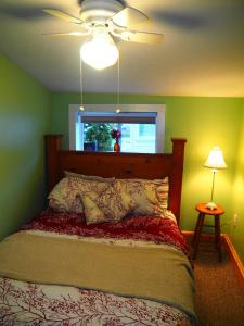 a bedroom with a bed with a ceiling fan and a window at New! The Turk Lake House - Lakefront With Toys! in Greenville