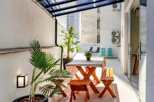 un patio de apartamentos con mesa y macetas en Apartamento com Terraço a 300m da Praia em Itapema P1771, en Itapema