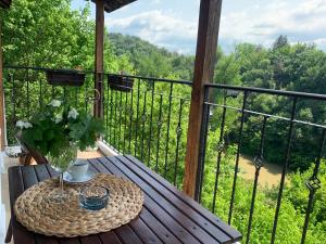 a table on a balcony with a view of the forest at Spring/Пролет Veliko Tărnovo in Veliko Tŭrnovo