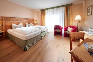 a hotel room with a large bed and a desk at Struck Landhotel & SPA in Attendorn