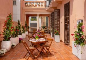 un patio con mesas, sillas y macetas en Antonios Hostal en Sitges