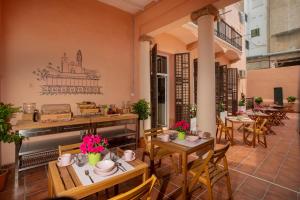 un patio con mesas y sillas en un restaurante en Antonios Hostal en Sitges