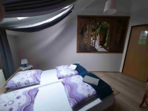 a bedroom with two beds with purple and blue pillows at Kraków Hostel in Krakow