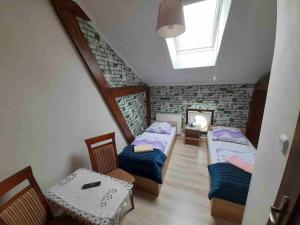 a attic room with two beds and a table at Kraków Hostel in Krakow