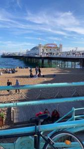 a pier with a group of people on the beach at Driftwood by the Sea in Brighton & Hove