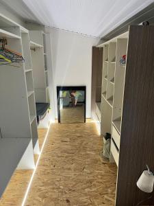 a room with white walls and a hallway with shelves at Maison des Coulicous - 1 à 2 chambres in Montjoly