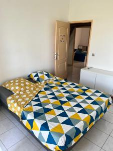 a bedroom with a bed with a colorful comforter at Maison des Coulicous - 1 à 2 chambres in Montjoly