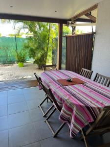 een tafel en stoelen op een patio bij Maison des Coulicous - 1 à 2 chambres in Montjoly
