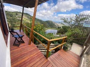 een houten veranda met een stoel en uitzicht op een rivier bij Refúgio Serra Negra - PE in Bezerros