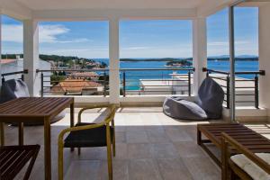 a balcony with tables and chairs and a view of the water at Rino in Hvar