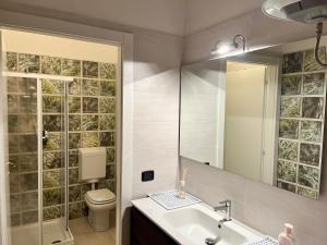 a bathroom with a sink and a toilet and a mirror at SUB 14 Suite Apartment - Vietato Fumare in Reggio Emilia